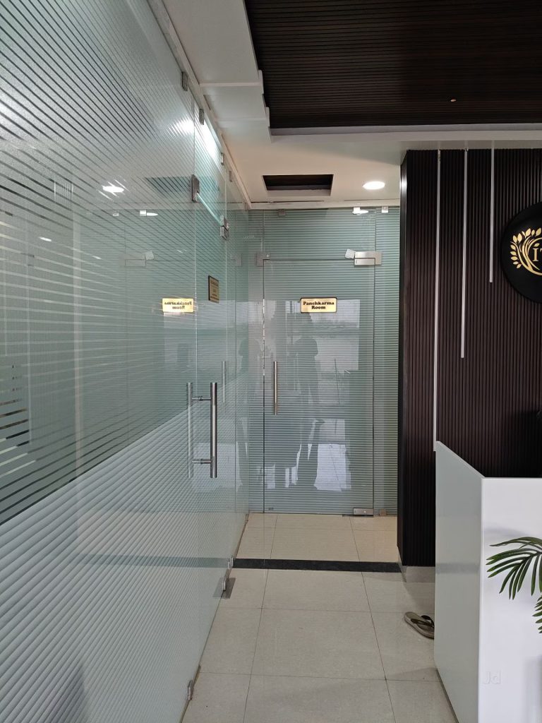 Modern reception desk and ITNOA Ayurved Clinic doorwall emblem inside the clinic